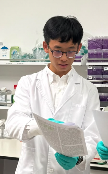 Student reading a research paper in a laboratory